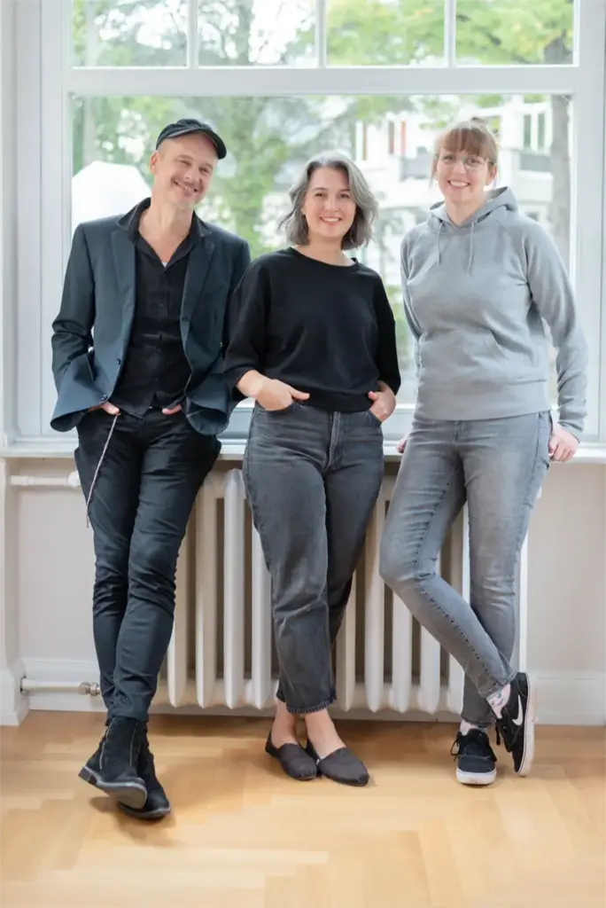 Ganzkörper Portrait Team w10b vor inem Fenster.